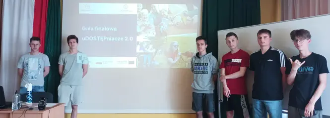 Zdjęcie przedstawia uczniów uczestniczących w projekcie Udostępniacze na tle plakatu z gali