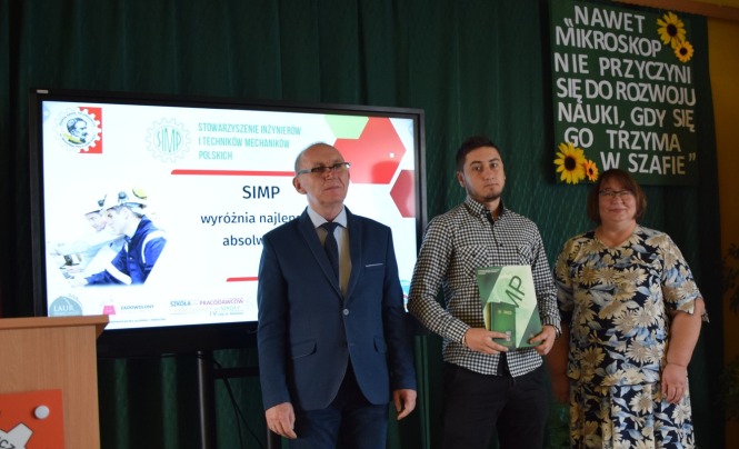 Jeden z nagrodzonych uczniów wraz z Dyrekcja i prezesem SIMP