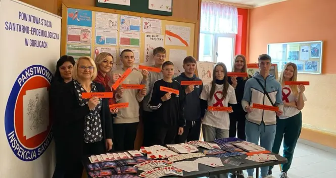 Uczniowie z panią z Sanepidu prezentują ulotki w światowym Dniu AIDS