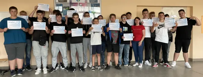 Grupa młodzieży wraz z opiekunem z certyfikatami Projektu Sieć Antysmogowa