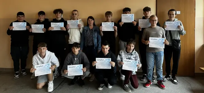 Grupa młodzieży wraz z opiekunem z certyfikatami Projektu Sieć Antysmogowa