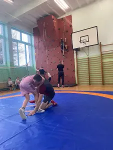 Dzieci ze szkoły podstawowej w Ropicy Polskiej ćwiczą na macie w sali gimnastycznej