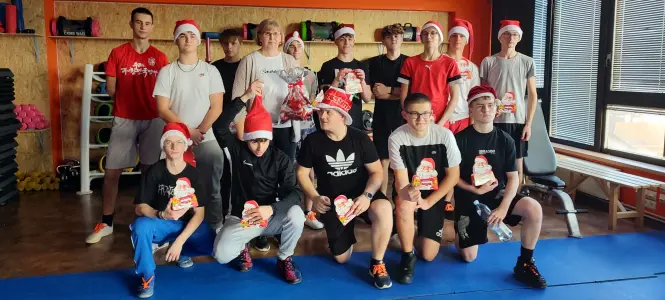 Grupa młodzieży w czapkach mikołajowych na siłowni